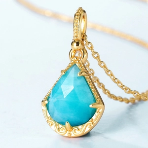 Gros plan du pendentif goutte en amazonite bleue avec monture dorée sculptée