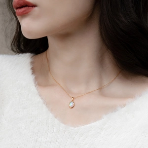 Elegant gold plated S925 silver necklace with oval synthetic opal pendant on a female model