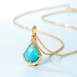 Vue macro d'un pendentif amazonite goutte sur une chaîne dorée en argent s925