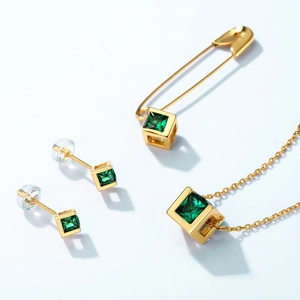 Collier en or et boucles d'oreilles émeraude avec zircon vert sur fond bleu clair