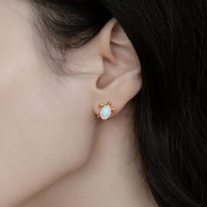 S925 silver turtle stud earrings with white fire opal worn on a female model