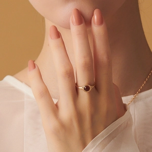 Close-up of a vintage S925 silver garnet ring with beaded gold setting on a model's hand