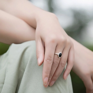 Detail of vintage textured silver ring with oval black onyx gemstone on model hand