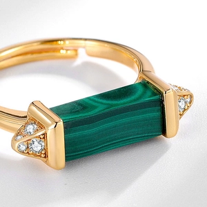 Macro detail of rectangle malachite gemstone and diamond inlay on a gold silver ring