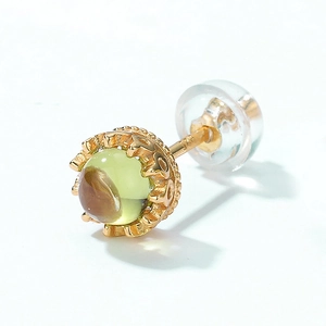 Macro shot of 18K gold crown stud earring with olive green gemstone and k18 engraving