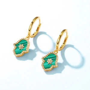 Gold Hamsa Hand earrings with green malachite and zircon accents on light blue background