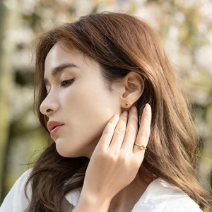 Detail shot of vintage 925 silver olivine earrings and ring set on model in natural light