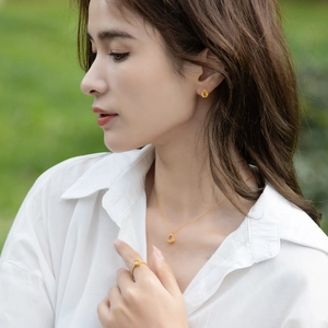 Close-up of model wearing gold pear-cut citrine earrings and matching jewelry set
