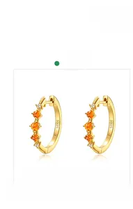 Détails macro des boucles d'oreilles en argent S925 avec grenat orange et zircons