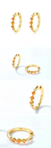 Vue macro de boucles d'oreilles en argent S925 avec grenat orange, zircons et fini poli