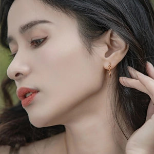 Gros plan de boucles d'oreilles créoles dorées en argent S925 avec grenats sur mannequin