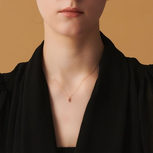 Détail d'un collier en argent S925 avec pendentif corindon rouge sur un mannequin