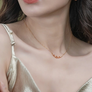 Élégant collier en or avec grenats orange et diamants porté par un mannequin en soie