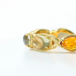 Vintage gold-plated ring with amber and green oval gemstones in ornate openwork setting