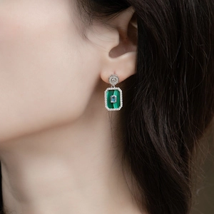 Detailed close-up of geometric malachite drop earrings with S925 silver on a female model