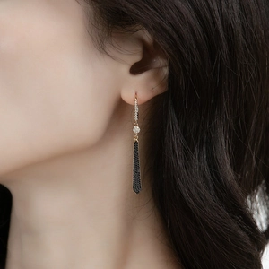 Elegant long tassel earrings in S925 silver with black zircons worn by a model