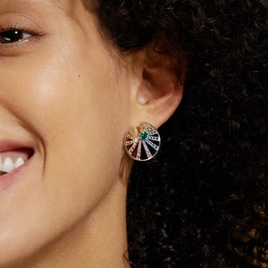 Macro detail of rainbow zircon stud earrings featuring multi-color gradient stones