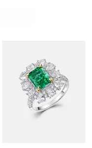 Détail macro de bague avec pierre verte taille émeraude et diamants carbone