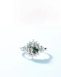 Macro detail of S925 sterling silver ring with green moss agate and white zircon halo