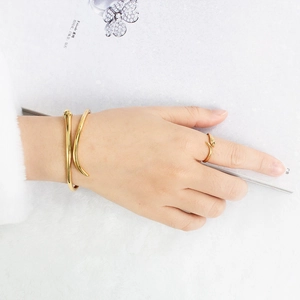 Gros plan sur un ensemble bracelet et bague serpent doré minimaliste sur un magazine de mode