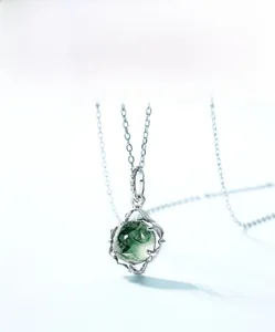 Macro shot of silver S925 moss agate pendant with natural green plant-like patterns