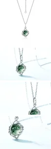 Macro shot of 925 silver leaf pendant with green moss agate and gold-plated details
