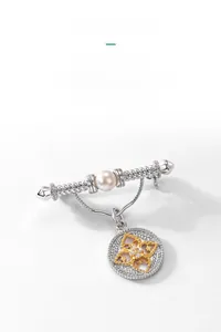 Close-up of vintage freshwater pearl brooch with hollow floral pendant and crystals