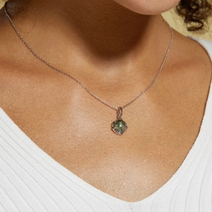 Close-up of S925 silver necklace featuring a green moss agate pendant on a model's neck