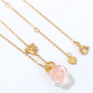 Detailansicht von goldener Biene und rosa Rose an einer feinen S925 Silberhalskette