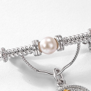 Vintage S925 silver brooch with freshwater pearl and pavé crystals on textured surface