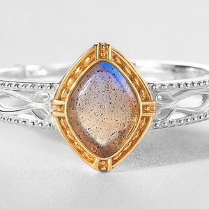 Macro shot of marquise labradorite with blue flash and intricate silver hollow pattern