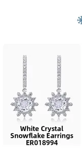 Gros plan de boucles d'oreilles flocon en argent avec cristal blanc et détails ciselés
