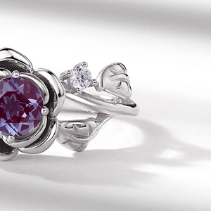 Macro detail of S925 silver rose ring with purple gemstone and leaf engraving