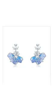 Close-up of blue gradient enamel flower earrings with sparkling crystal accents