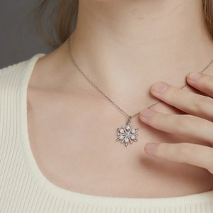 Elegant snowflake pearl necklace with silver chain shown on a female model