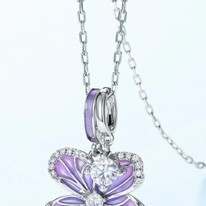 Détail macro du pendentif orchidée en émail violet et zircons blancs sur chaîne argent