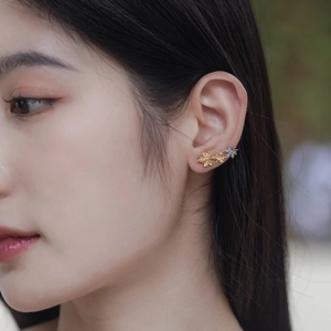 Detail of S925 silver maple leaf earrings with gold plating and sparkling zircon stones