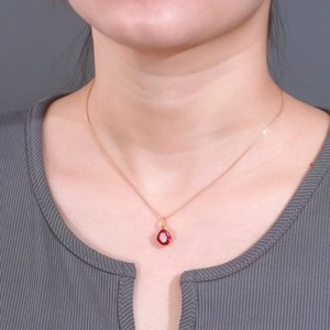 Elegant 925 sterling silver necklace with faceted wine red corundum pendant on a model