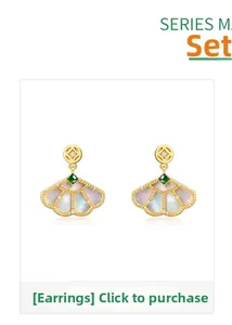 Detailed view of fan-shaped S925 silver earrings with white shell and green emerald gemstone