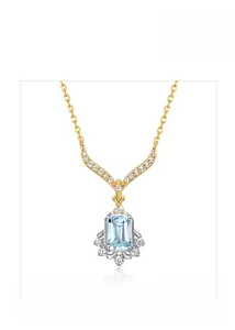 Close-up of emerald cut sky blue topaz pendant with micro-pave diamonds in gold plating