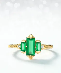 Macro shot of green agate ring with stepped cut stones and textured golden band