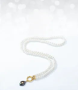 Detailed shot of double-layer pearl chain necklace with abalone shell drop and gold clasp