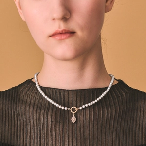 S925 silver pearl necklace with starburst rhombus pendant on model with orange background