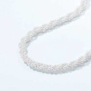 Macro detail of multi-strand twisted pearl necklace with elegant round white pearls