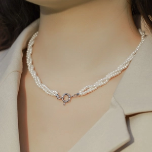 Elegant multi-layer pearl necklace with silver spring clasp on a model in a beige blazer