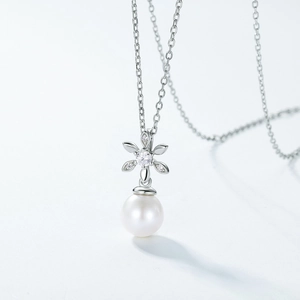 Macro shot of S925 sterling silver magnolia flower pendant with freshwater pearl and zircons