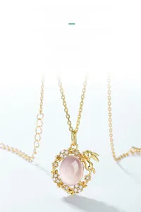 Macro detail of S925 sterling silver rabbit pendant with pink rose quartz and gold floral motif