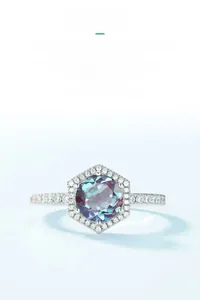 Macro detail of Alexandrite ring featuring hexagonal halo and round-cut color-changing stone