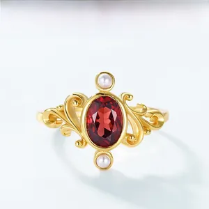 Detail of vintage sterling silver crown ring with oval red garnet and white pearls