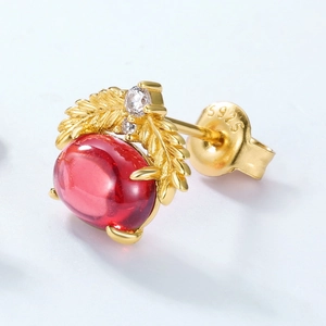 Gros plan du poinçon S925 sur boucles d'oreilles vintage en argent et grenade rouge